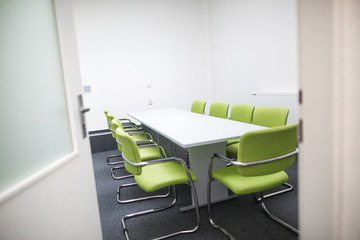 Interior of modern boardroom with green armchairs