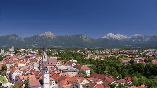 Wide aerial shot leaving village near mountain range / Kranj, Slovenia