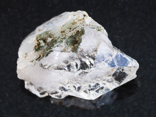 rough rock crystal of quartz gemstone on dark