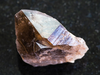 rough crystal of smoky quartz gemstone on dark