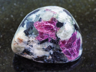 tumbled pink Corundum crystals in rock on dark
