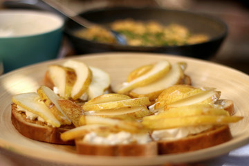 Slices of whole wheat bread with goat cheese and pears. Selective focus. 
