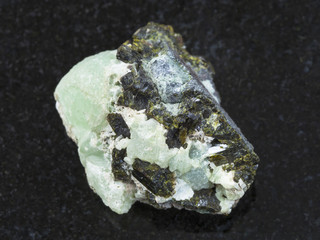 Epidote crystals on prehnite gemstone on dark