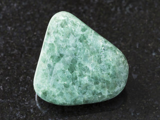 tumbled green Jadeite gemstone on dark