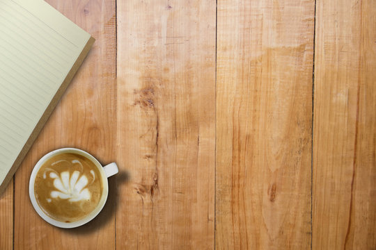 Empty book and hot coffee over wooden board table, copy space for presentation product, mock up