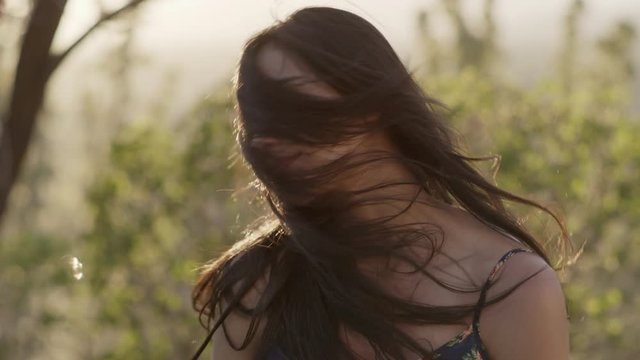 Close up slow motion shot of woman tossing hair outdoors / Cedar Hills, Utah, United States