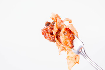 Pappardelle with bolognese sauce on a fork on a white background