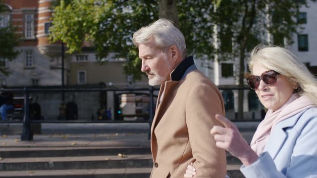 Attractive mature couple walking and talking in the city, in slow motion