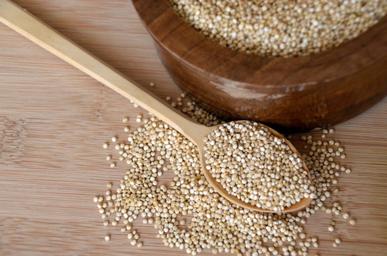 Quinoa in a wooden spoon on the table. Healthy eating. Vegan food concept
