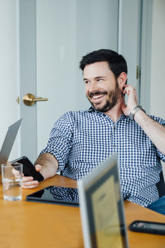 Smiling Caucasian businessman holding cell phone