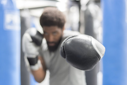 Portrait of Black man wearing boxing gloves in gymnasium
