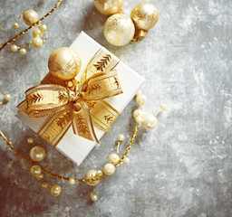 Christmas present with golden ornaments on gray background