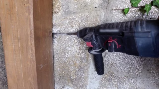 Man drilling a hole in the wall