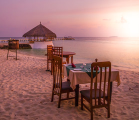 Tropical island vacation image, sunset dinner table on the beach, Maldives