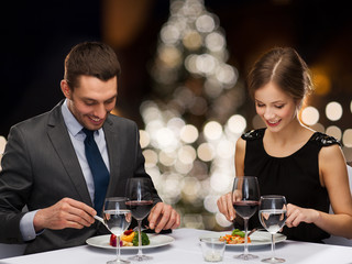 smiling couple eating at christmas restaurant