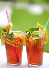 Fresh ice tea glass with ice, lemon, orange, ice tea, peach, straw, relax, fruit piece