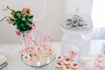 Wedding reception dessert table with delicious decorated white cupcakes with frosting