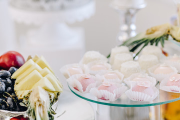 Wedding reception dessert table with delicious decorated white cupcakes with frosting