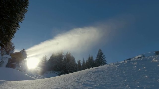 Powerful cannon spreading fresh snow on ski slope