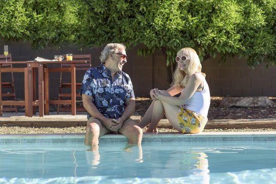 Caucasian couple laughing near swimming pool
