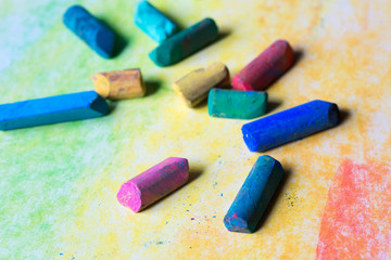 pastel crayons on multicolored paper background