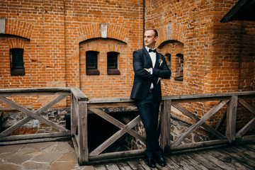 Funny and handsome groom in the castle