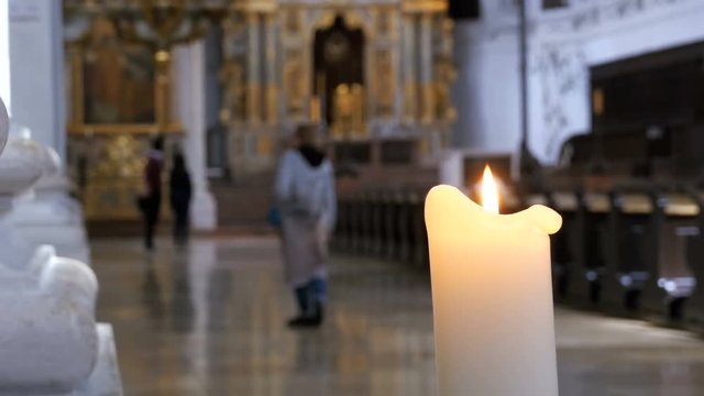 MUNICH, GERMANY, SEPTEMBER 15, 2017: The candle burns in the church of St. Michael. Munich, Germany. Architecture Christian Orthodox Church Interior. Religious People in Orthodox temple.