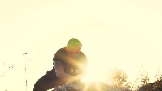 The brutal man beating the stone with hammer on the rock. Slowly