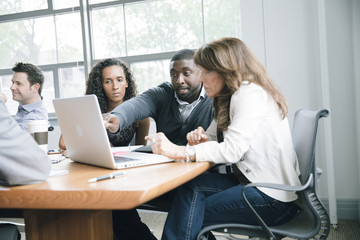 Business people using laptop in meeting