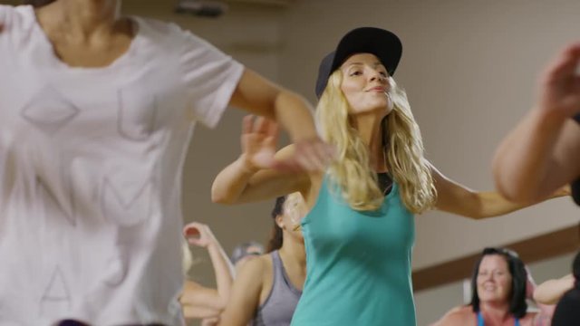 Medium panning shot of women dancing in exercise class / Orem, Utah, United States