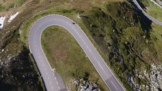Wide aerial high angle shot of person riding motorcycle on mountain pass / Grossglockner, Austria