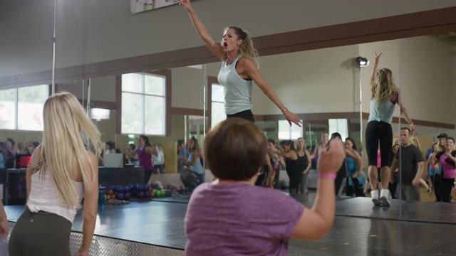 Medium panning shot of instructor leading exercise class / Orem, Utah, United States