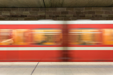 Moving red and white subway in the underground going past