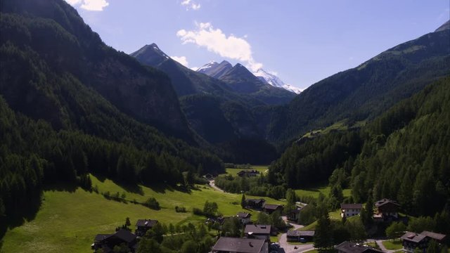 Wide aerial shot of houses in rural valley town / Heiligenblut, Austria