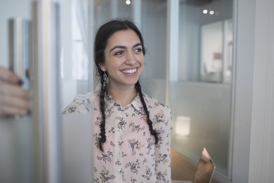 Young woman in office corridor smiling