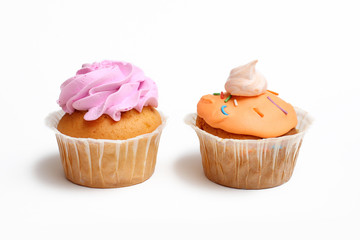 two cupcakes in icing with meringue on a white background