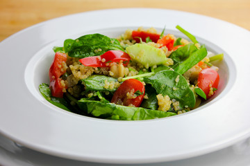 Quinoa salad with tomatoes, spinach and cucumbers