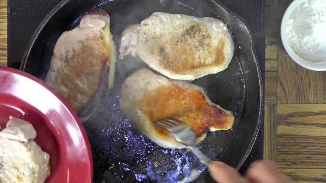 Removing fried boneless pork chops from a pan