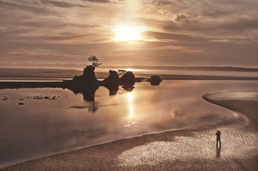 Obraz na płótnie Canvas Sunset landscape on Pacific Ocean beach/Sunset landscape on Pacific Ocean coastline with photographer in silhouette