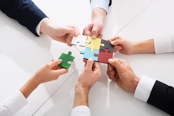 Teamwork of partners. Concept of integration and startup with puzzle pieces - obrazy, fototapety, plakaty