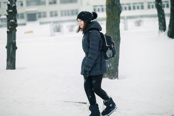 Girl schoolgirl with a school backpack over her shoulders runs to school.