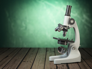Microscope on wooden table and green vintage background