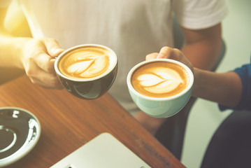 Couple hands holding coffee cup with latte art