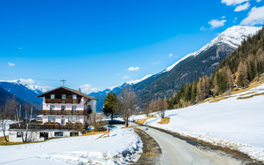 Amazing view of winter wonderland mountain scenery with traditional mountain chalet in the Alps on a sunny day with blue sky