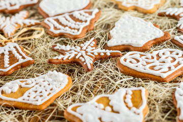 Homemade christmas gingerbreads on wooden boards and straw, the Christmas or New Year background
