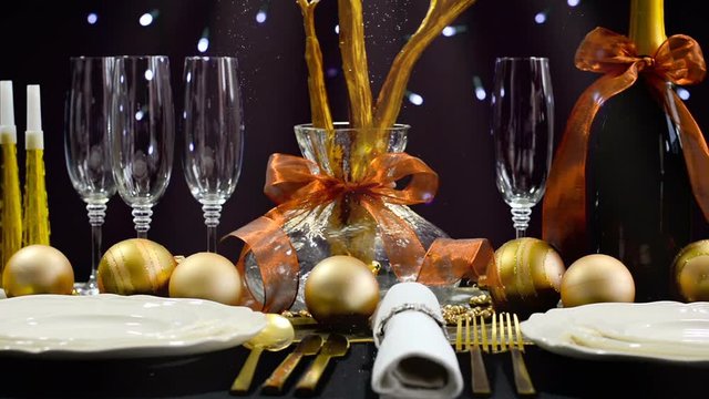 New Years Eve party dinner table with gold, white and black theme with Christmas fairy lights background, with downward glittering light beams.