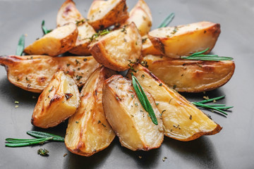 Delicious baked potatoes with rosemary on plate