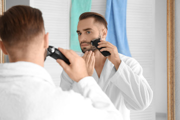 Morning of handsome young man shaving in bathroom