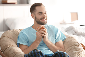 Morning of handsome young man drinking coffee at home