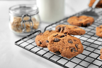 Delicious oatmeal cookies with chocolate chips on metal grid, close up